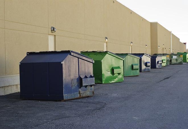 construction workers loading debris into dumpsters on a worksite in Fernley